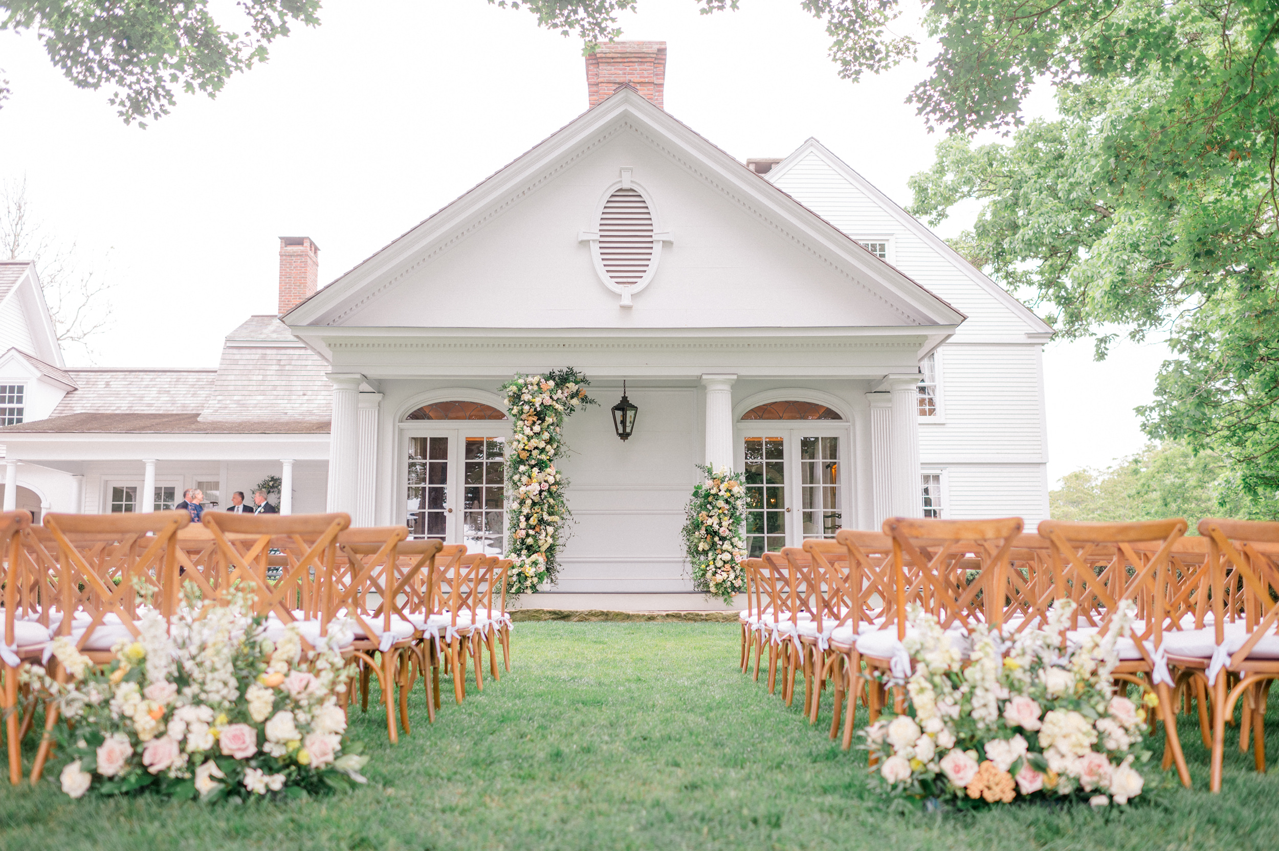 One of the many ceremony location at Smith Farm Gardens featuring columns, climbing floral, and wooden chair for guests