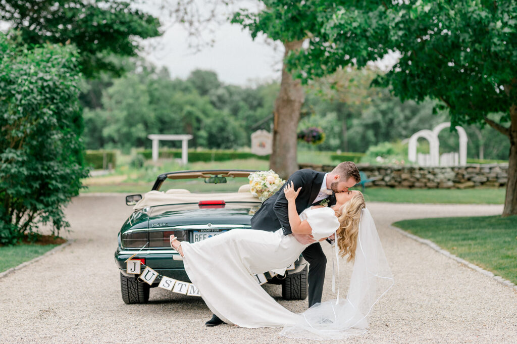 bride and groom dip near a just married vintage car