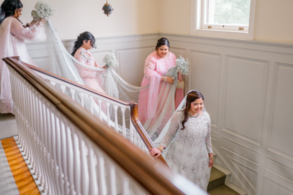 bride ascending staircase with bridesmaids for eolia mansion wedding