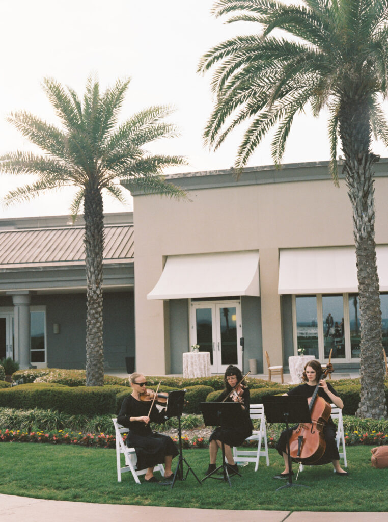 Trio of string instruments play during wedding ceremony. 