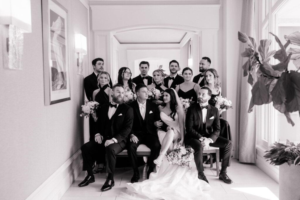 Black and white photo of bridal party seated together in bridal suite of the Ritz Carlton Amelia Island. 