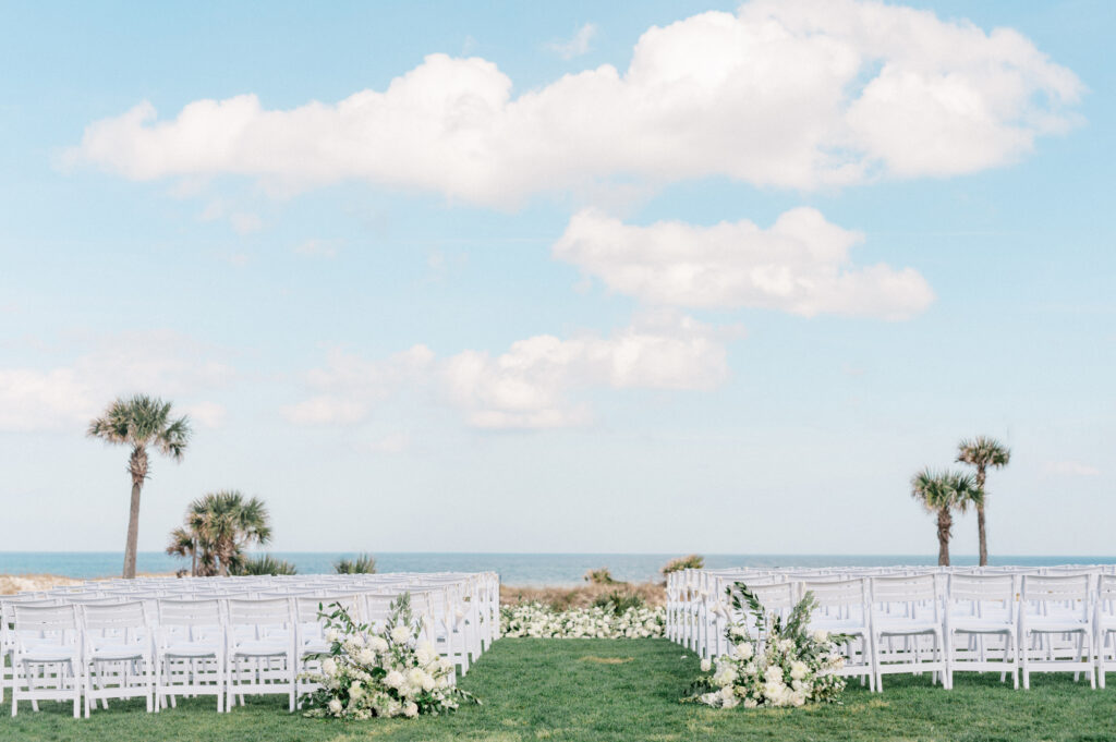 Folding white chairs sit in the courtyard lawn before wedding at the Ritz Carlton Amelia Island. 