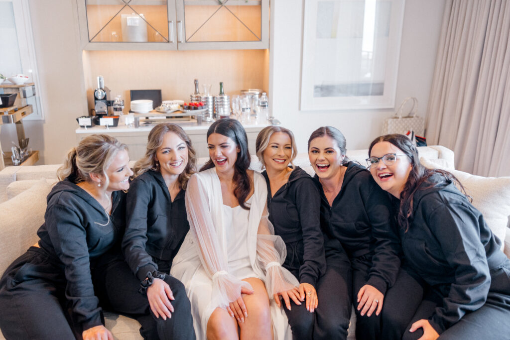 Bride sits with bridesmaids in their getting ready suite before wedding at the Ritz Carlton Amelia Island. 