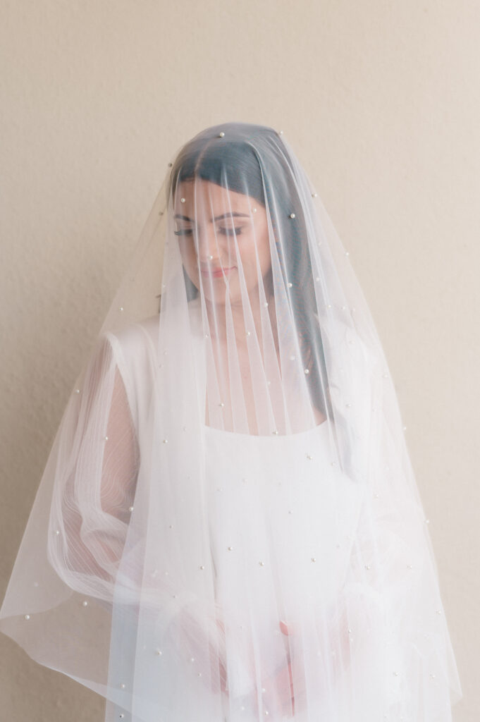 Dramatic bridal portrait with pearl veil draped over the brides face.