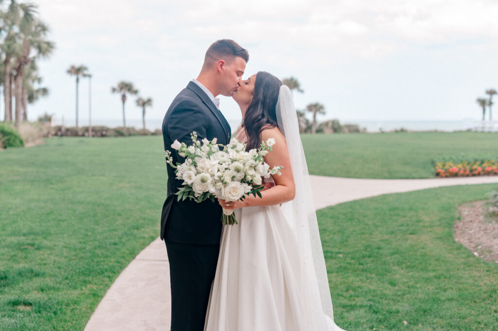 Bride and groom kiss for portraits before wedding at the Ritz Carlton Amelia Island. 