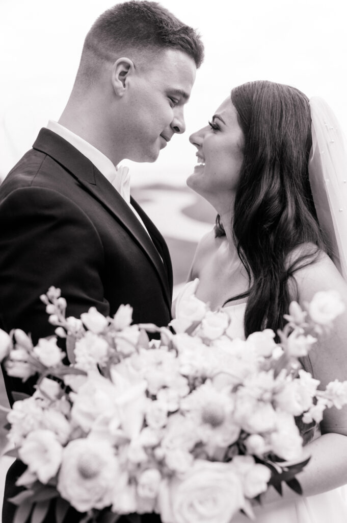 Bride and groom embrace in this cinematic black and white photo. 