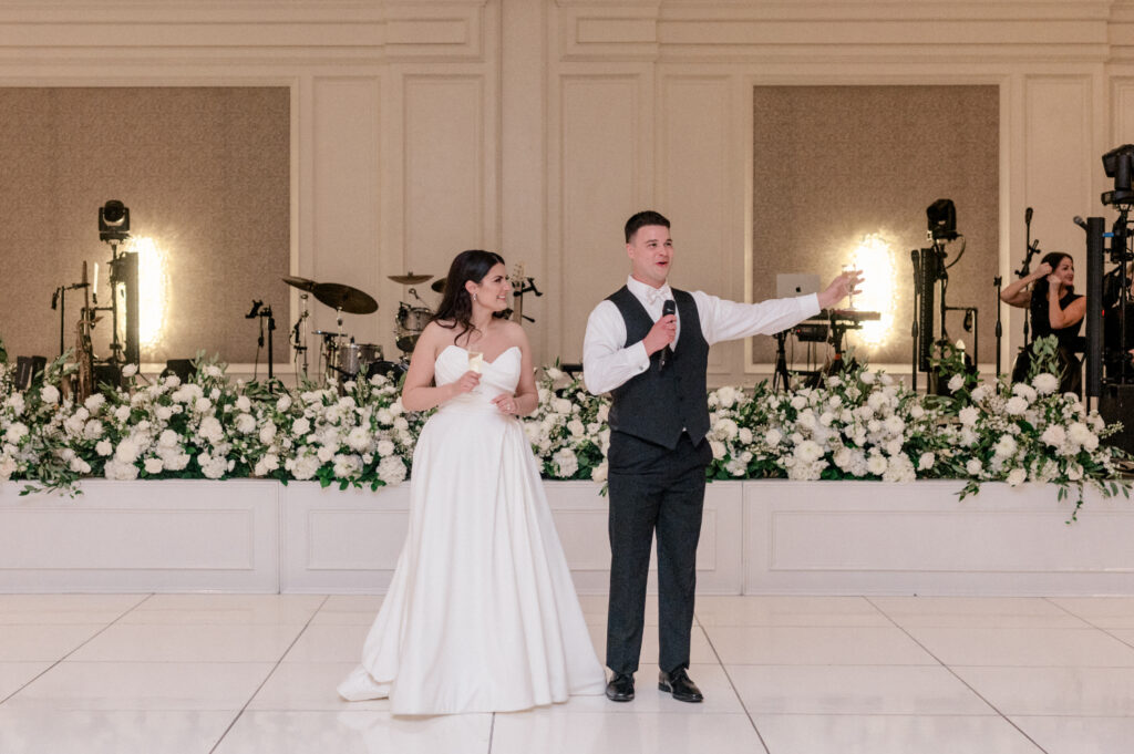 Bride and groom giving toast during their wedding reception, thanking guests for being their for their journey. 