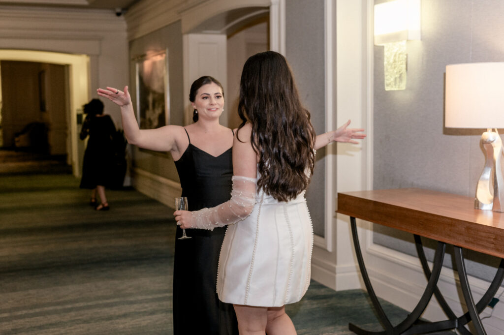 Guest greeting bride with open arms after the bride reappears with a different dress. 