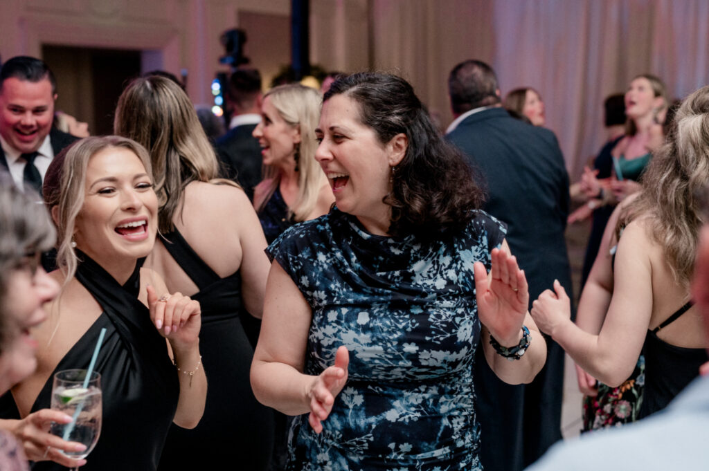 Guests dance together to live band during wedding reception. 