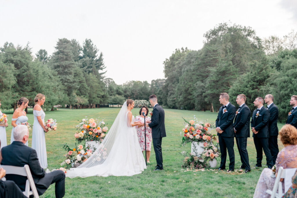 Bride and groom exchange vows during their outdoor wedding ceremony at Wadsworth Mansion.