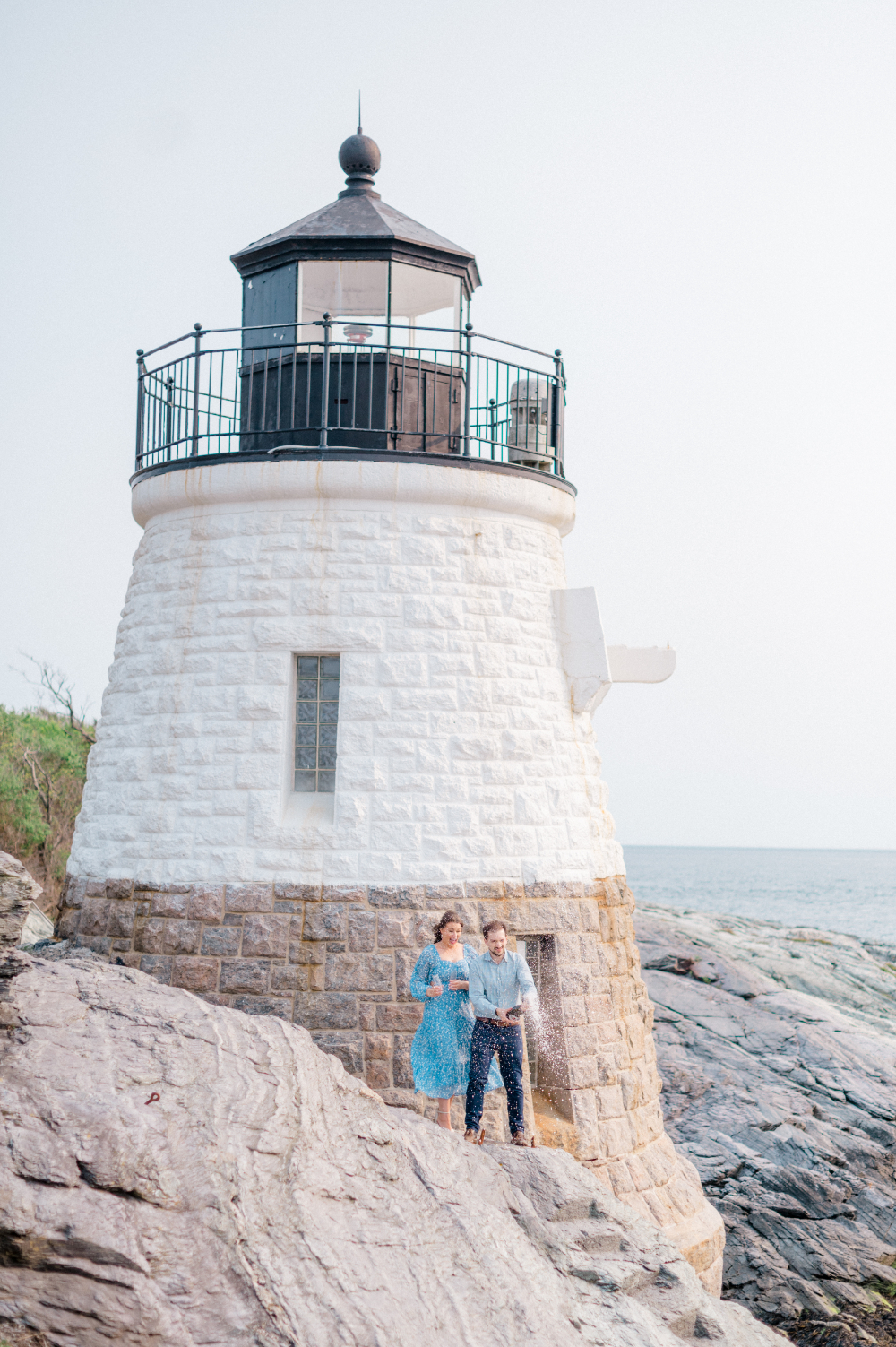 couple with a foaming champagne bottle at the lighthouse