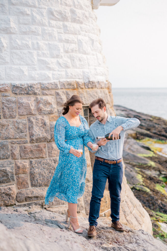 couple pouring a glass of champagne to celebrate their engagement photos