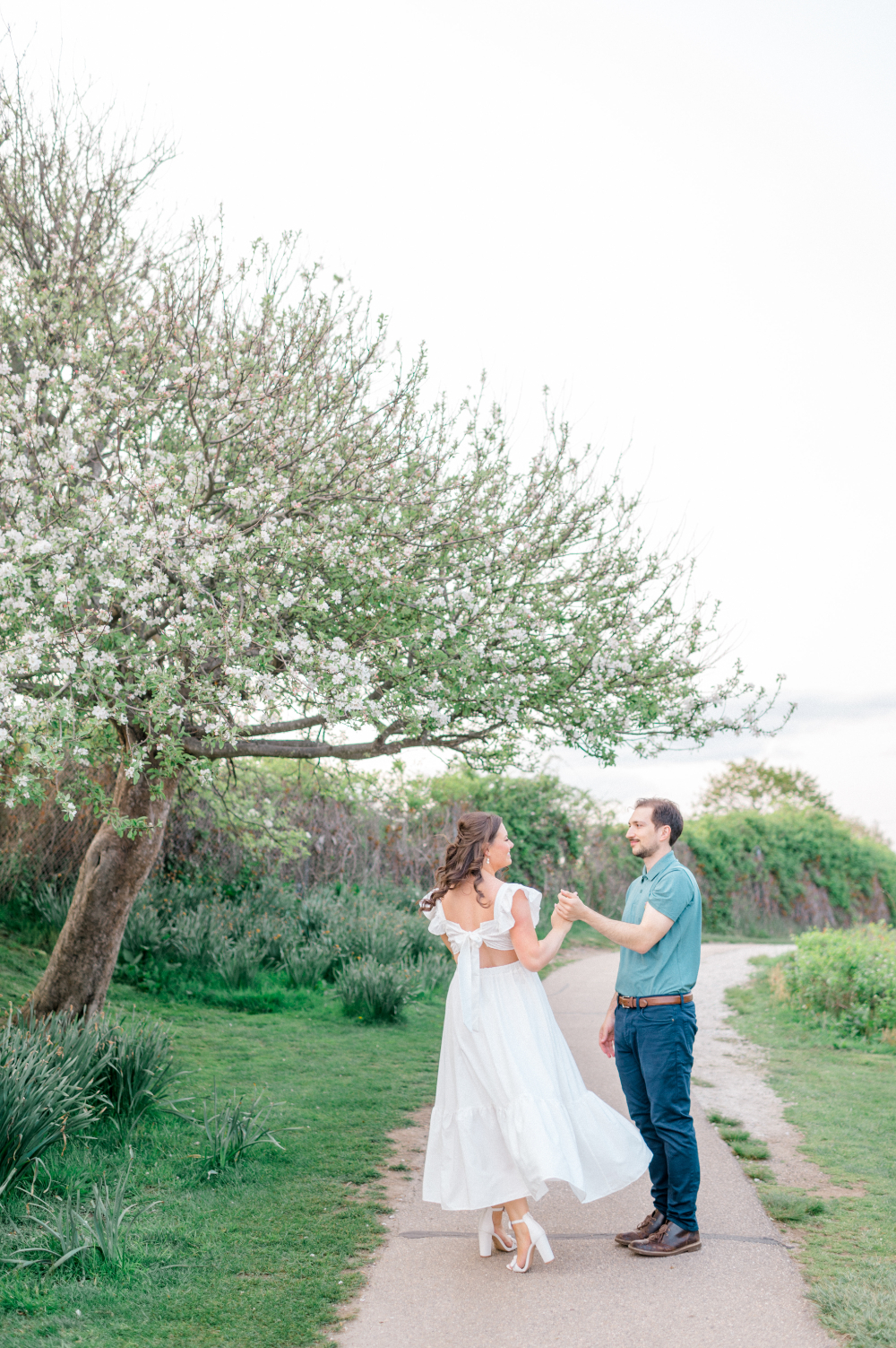 couple sharing a dance on a lush green pathway