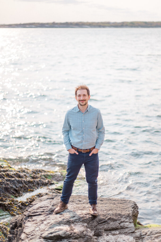 groom to be by the water during his engagement photos