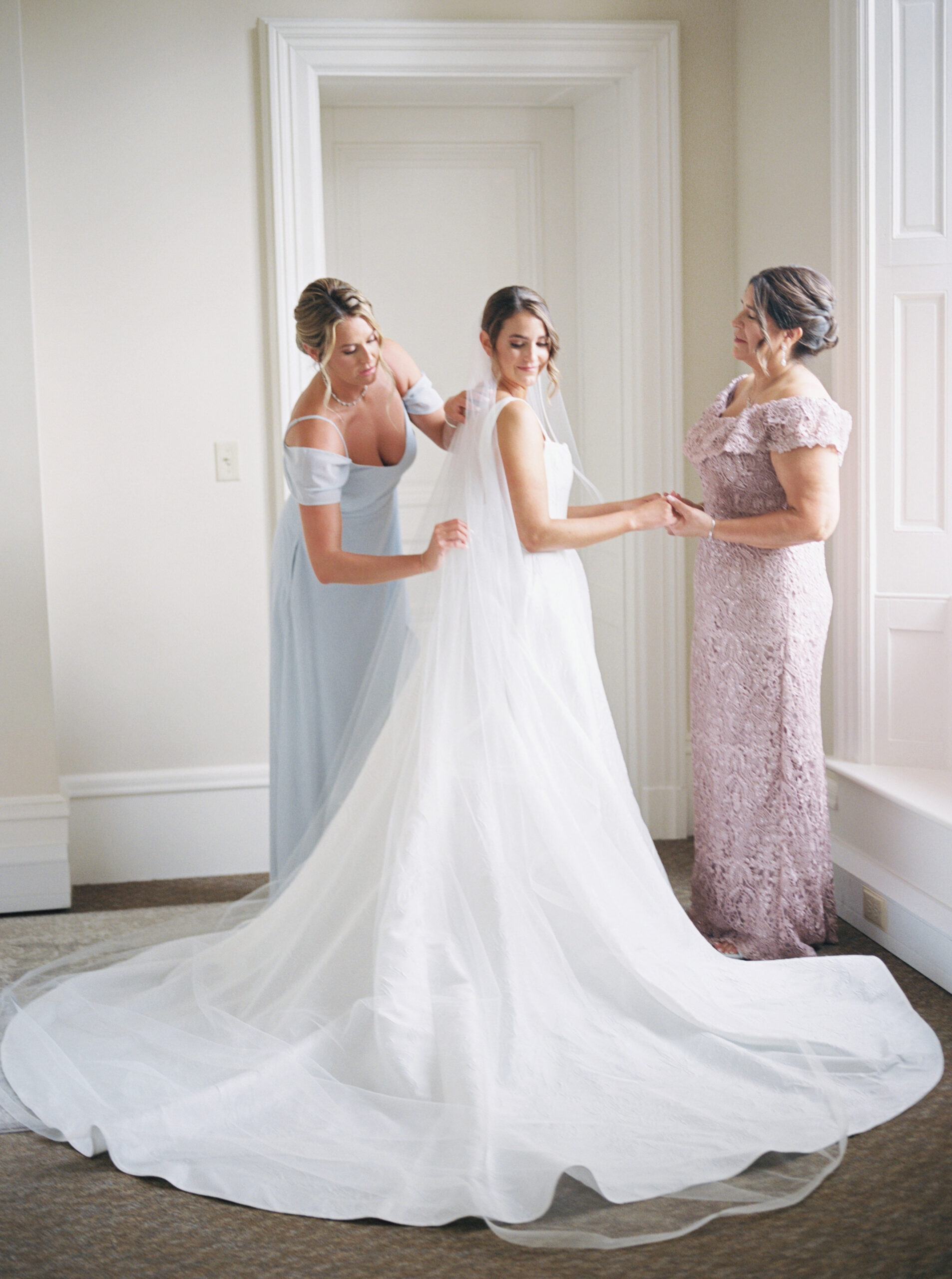 bride getting erady with mother and sister