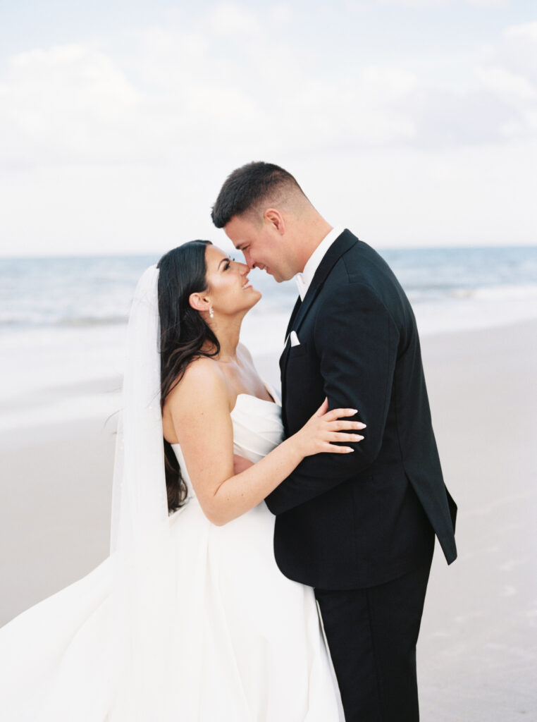 bride and groom taking portraits on the beach