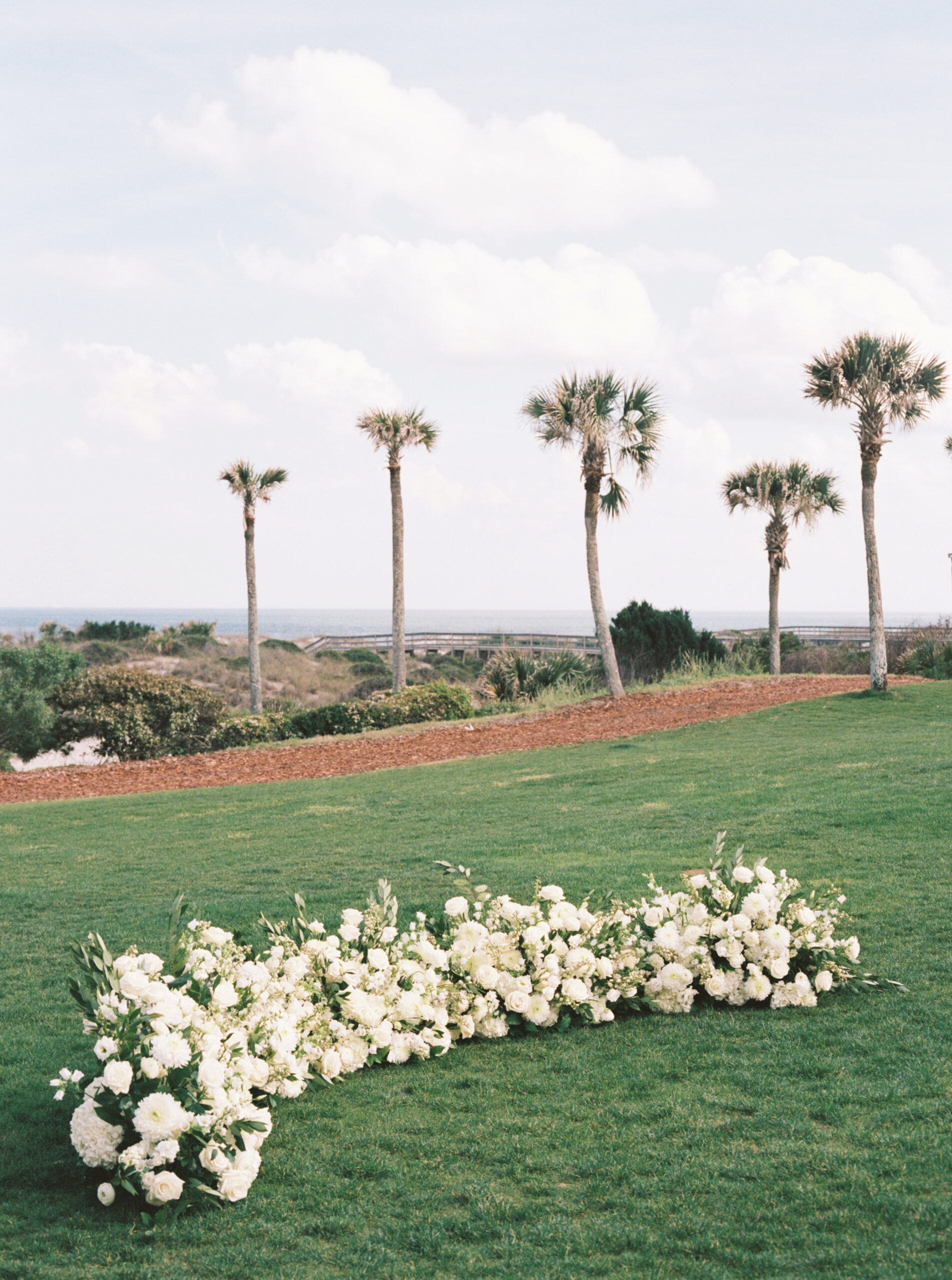 floral ceremony altar outdoors with palm trees in the background