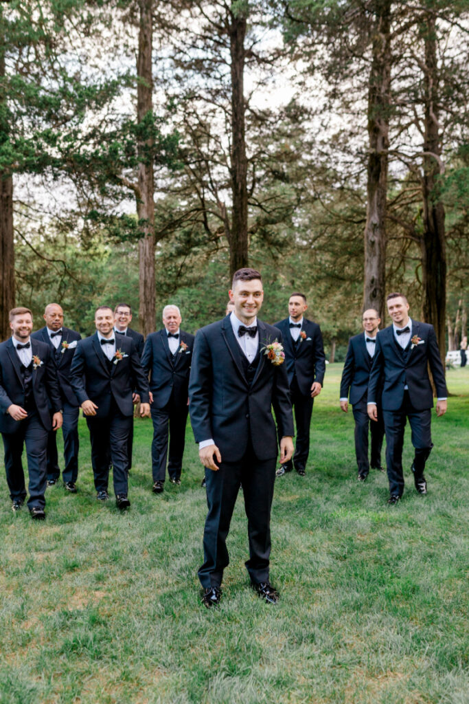 Groom and his groomsmen in classic and timeless black tuxedos 