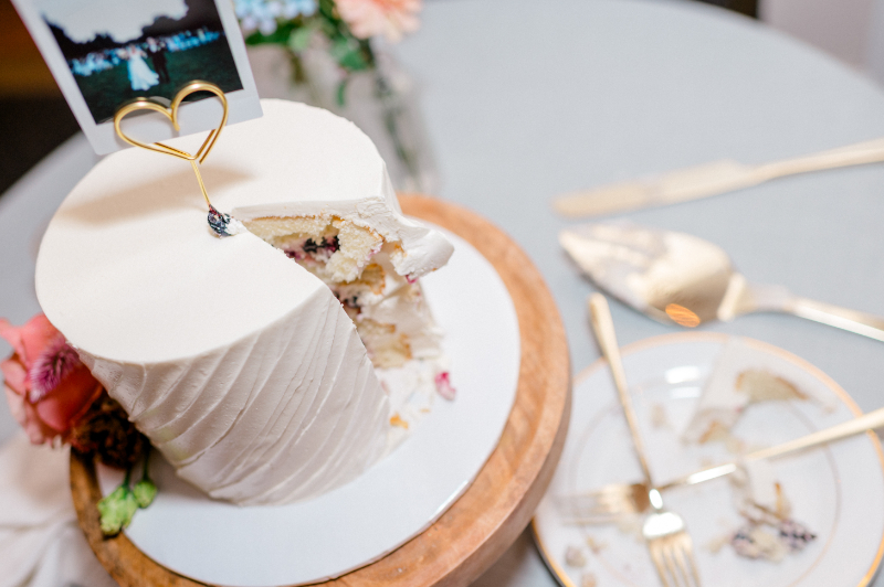 Beautifully minimalistic single-tier cake with a heart-shaped gold wire stand 