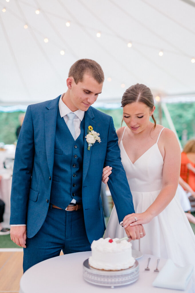 Alexis and Doug share a joyful moment as they cut their elegant white cake during the Smith Farm Gardens reception.