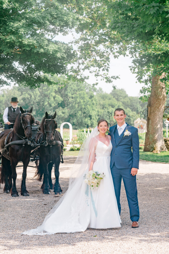 Connecticut wedding portrait of couple standing with elegant black horses and carriage driver at Smith Farm Gardens.