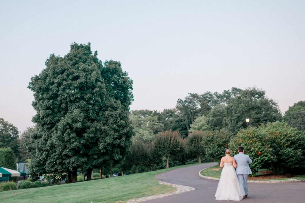 Bride and groom walking arm in arm at sunset on a winding path, a quiet candid wedding photography moment by Jennifer Nichole & Co.