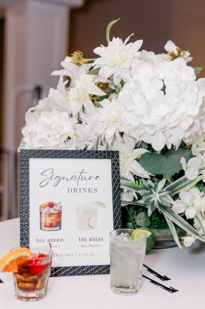 Signature drink display with floral arrangement and cocktail signage at Newport Harbor Island wedding.
