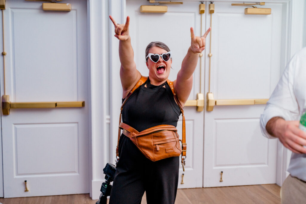 Jennifer Nichole celebrating on the dance floor in heart sunglasses at a Newport Harbor Island Resort wedding.