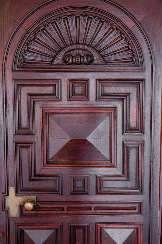 Close-up of intricate wooden door detail at Branford House, a unique touch of historic charm for weddings