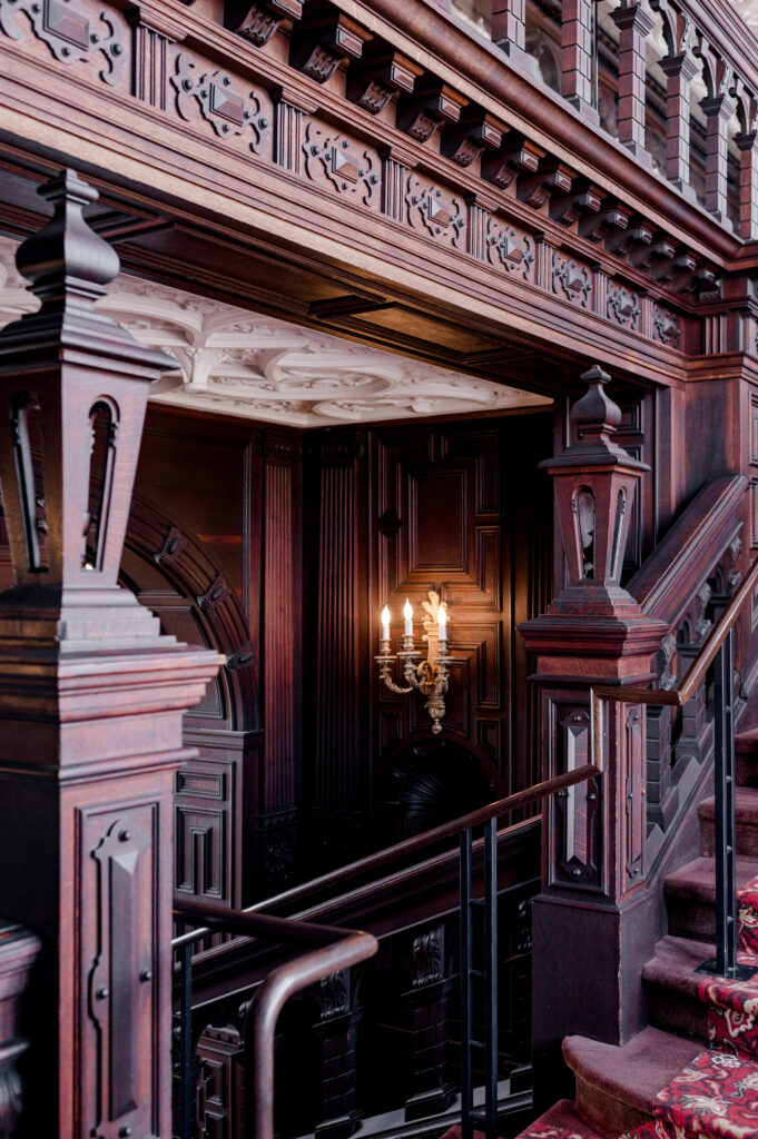 Romantic candlelit staircase with dark wood detail at Branford House Mansion, ideal for wedding portraits