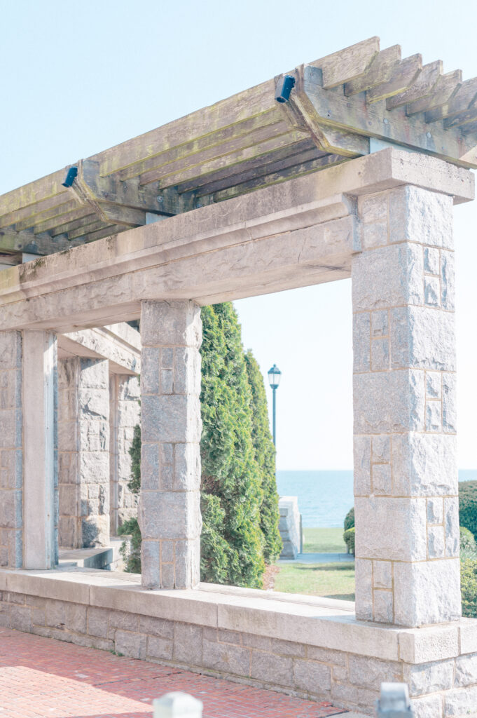Stone pergola at Branford House wedding venue with ocean views in the background on a sunny day