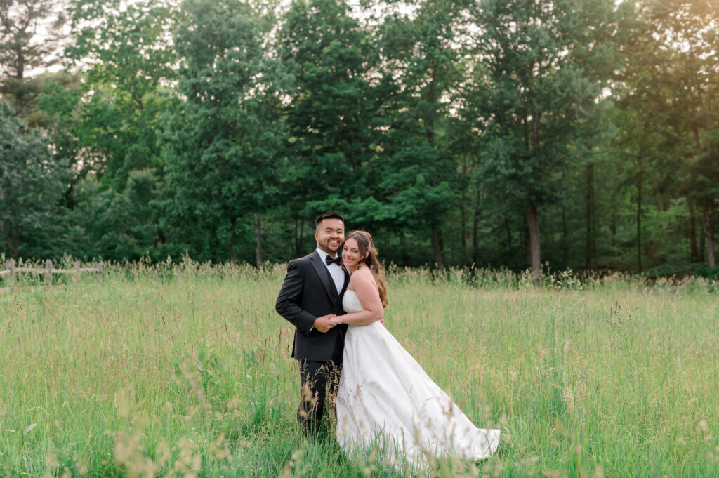 Bride and groom holding hands in an open green field at Smith Farm Gardens during golden hour by Jennifer Nichole photography