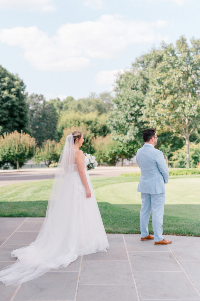 Bride approaches groom for a joyful first look moment during romantic Smith Farm Gardens wedding