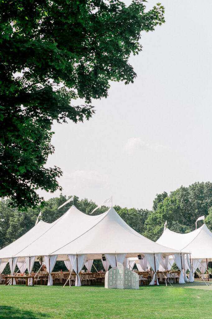 Elegant sailcloth tent exterior with white draping and lush lawn, photographed as part of the Connecticut wedding reception timeline by Jennifer Nichole Photography.