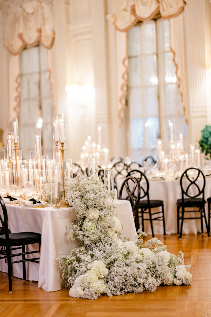 Luxurious Connecticut wedding reception decor featuring dramatic floral installation of white hydrangea and baby’s breath cascading from banquet table, photographed by Jennifer Nichole.